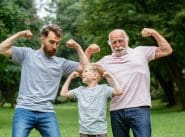 Portrait og happy family - grandpa, father and his son smiling and showing their muscles outdoor in park on background. Three different generation concept. Portrait og happy family - grandpa, father and his son smiling and showing their muscles outdoor in park on background. Three different generation concept.